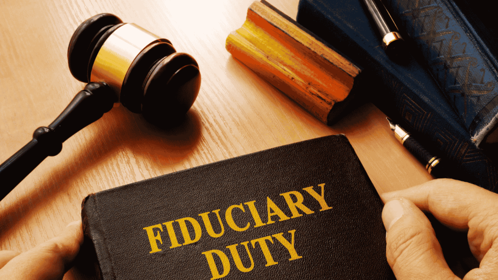 A collection of law related items on a table including a book labeled “Fiduciary Duty.”