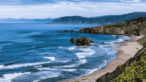 A coast in Northern California with mountains in the distance.