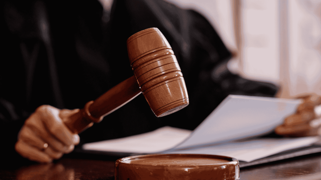 A judge holds a paper in one hand and their gavel in the other.