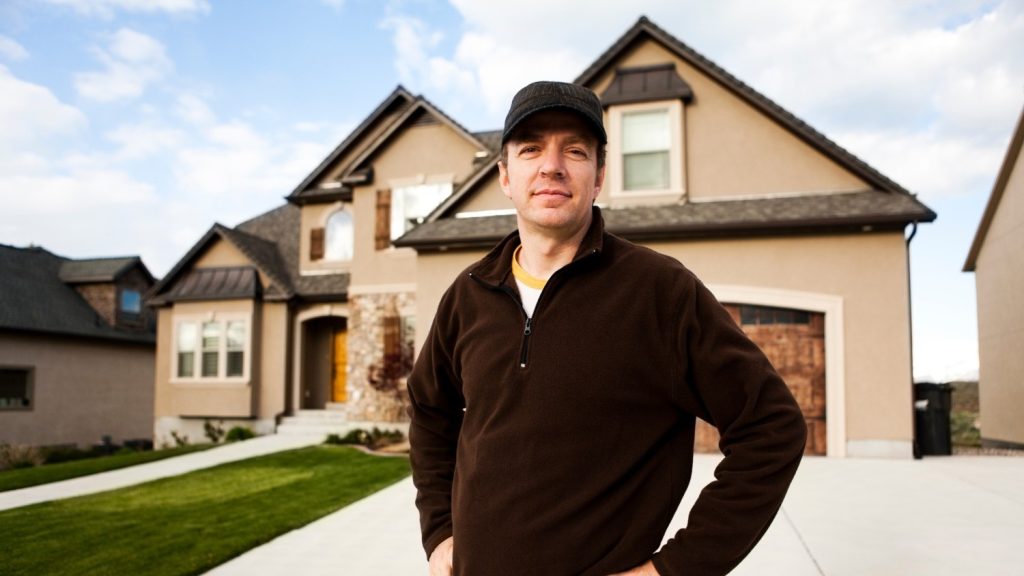 A property owner stands out front of a recently constructed building.