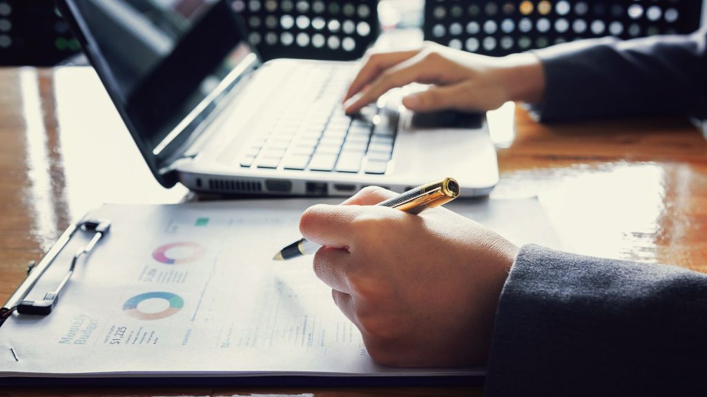 An Administrator uses a pen to examine paperwork.
