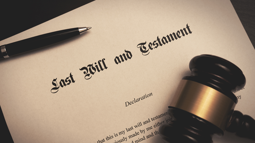 A close-up image of someone’s last will and testament next to a pen and gavel.